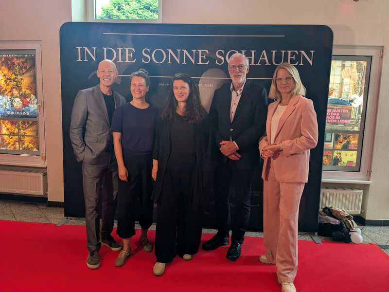 Minister Robra mit Filmcrew vor Filmplakat